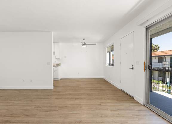 A room with a sliding glass door leading to a balcony.
