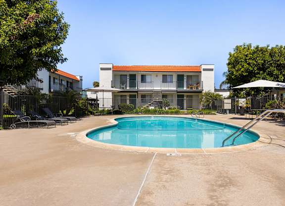 A swimming pool in front of a house.