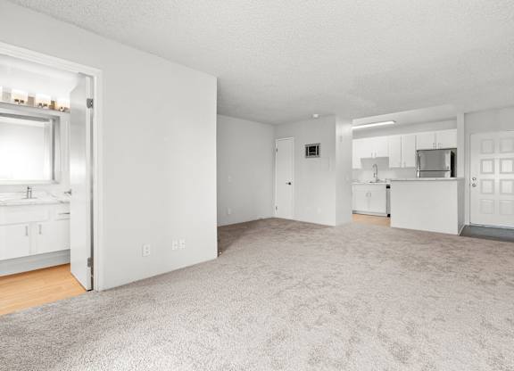 A large, empty room with a carpeted floor and white walls.