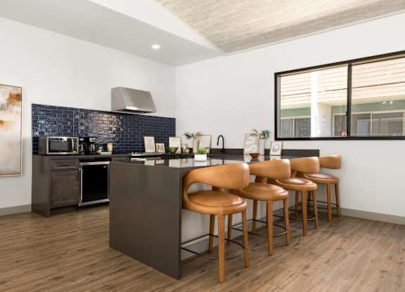 A kitchen with a bar stool and a counter.