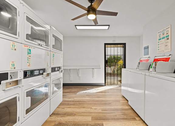 A row of white ovens are lined up in a kitchen.