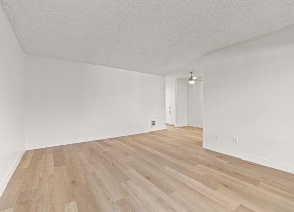 A room with wooden flooring and white walls.