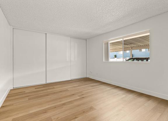 Empty room with white walls and wooden floor.
