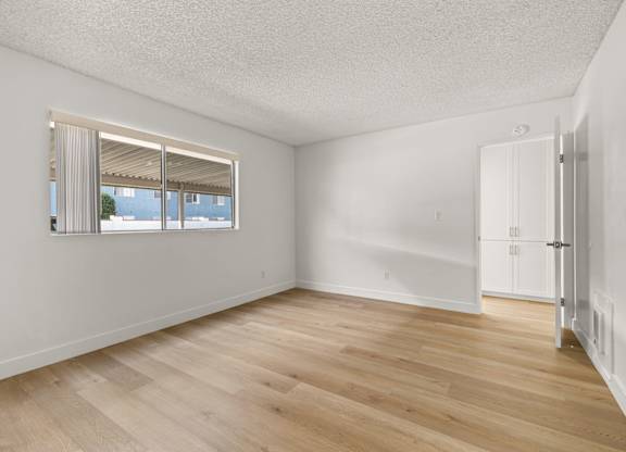 A room with a window and wooden flooring.
