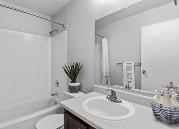 A bathroom with a white sink and a white toilet.