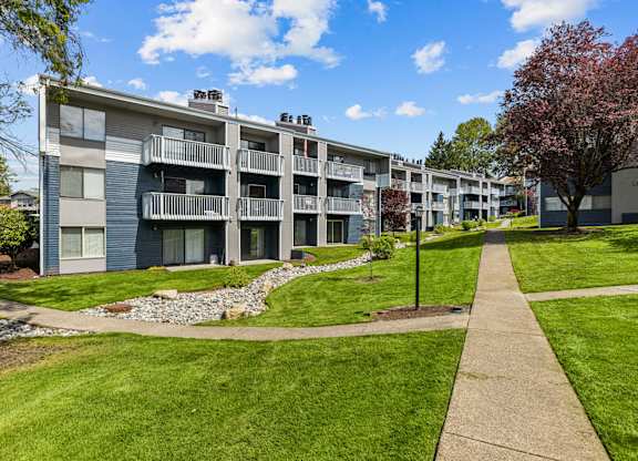 Apartment complex with a walkway in front.