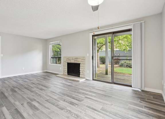 A room with a fireplace and sliding glass doors.