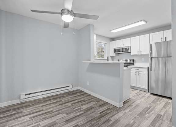 A kitchen with a refrigerator, stove, and cabinets.