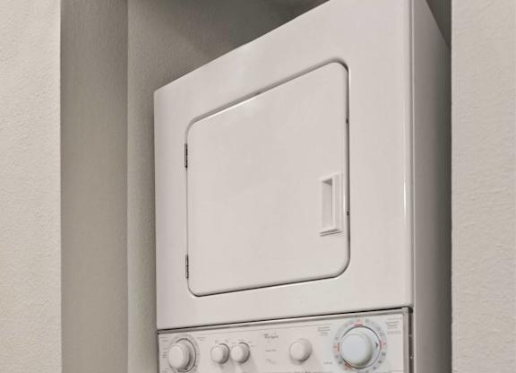 A white oven and dishwasher are mounted on a wall.