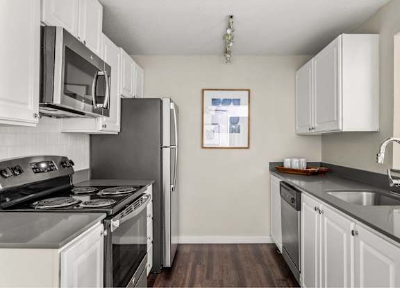 A kitchen with white cabinets and a black stove top oven.