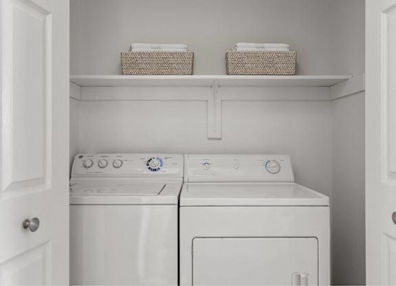 A small laundry room with a washer and dryer.
