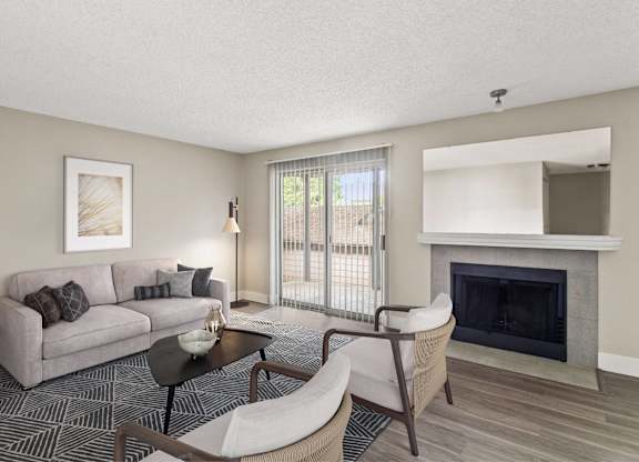 A living room with a grey couch, a black coffee table, and a fireplace.