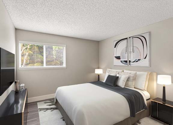 A bedroom with a large bed and a television on the wall.
