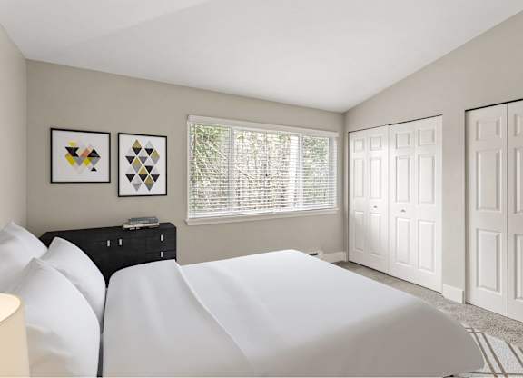 A bedroom with a white bed and two framed pictures on the wall.