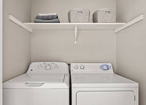 Two white washing machines in a laundry room.