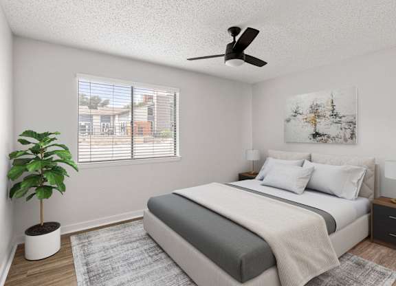 A bedroom with a bed, nightstand, and a plant.