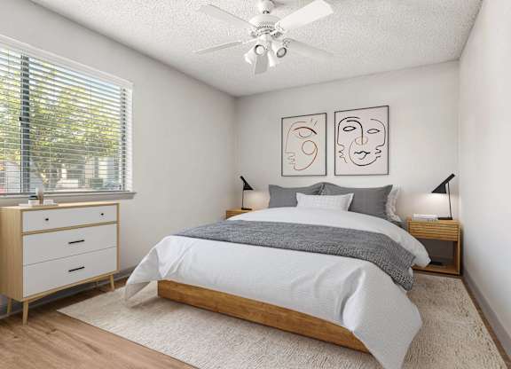 A bedroom with a bed, nightstands, and a ceiling fan.