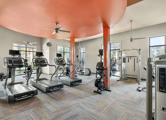 A gym with treadmills, elliptical machines, and other exercise equipment.