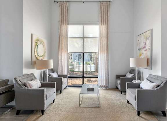 A living room with grey couches and a large window.