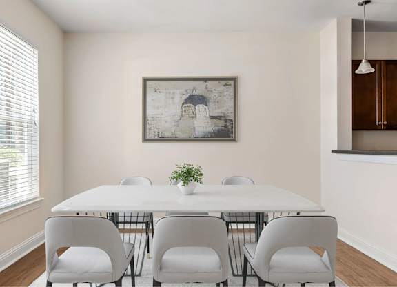 A dining room with a white table and chairs.