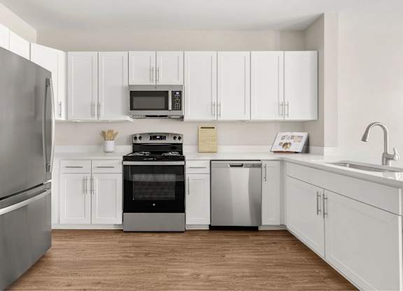 A kitchen with appliances and white cabinets.