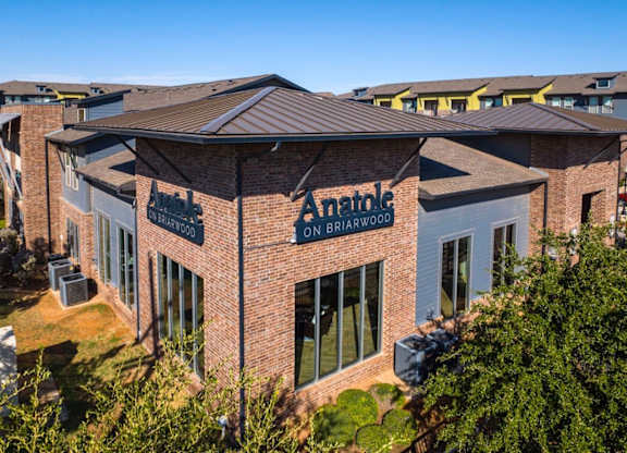 A brick building with a sign that says Anatole on it.