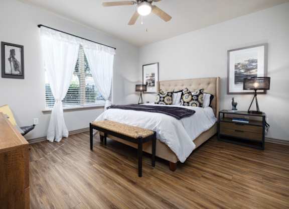 A bedroom with a bed, nightstand, and window.