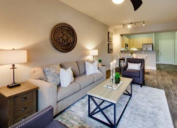 A living room with a couch, a coffee table, and a ceiling fan.