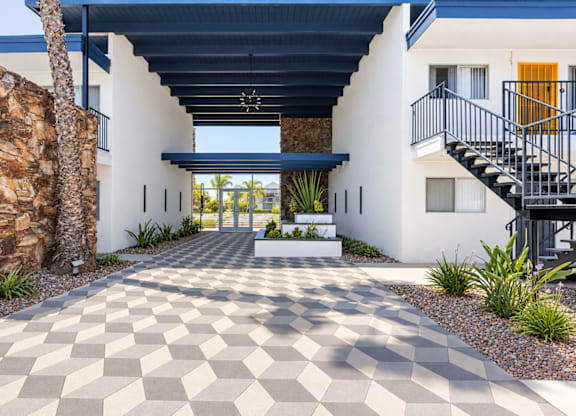 A modern house with a checkered floor leading to the front door.