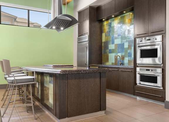 A modern kitchen with a green wall and a wooden island.