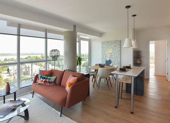 Open concept living room with orange sofa at 929 Richmond Apartments, Ottawa, ON