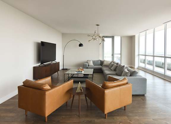 Spacious living room with leather accent chairs at 929 Richmond Apartments, Ottawa