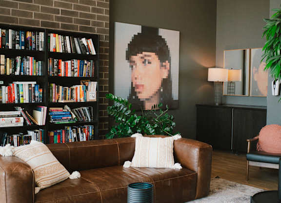 Living room with leather sofa and bookshelf at 929 Richmond Apartments, Ottawa, ON