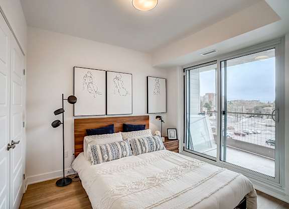 A bedroom with a large bed and a view of the outside.