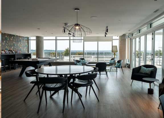Modern dining room with round table and seating at Baseline Apartments, Ottawa, Ontario