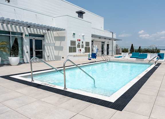 Rooftop swimming pool with deck furniture at Baseline Apartments, Ottawa