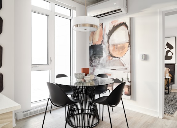 A modern dining room with a large abstract painting on the wall.