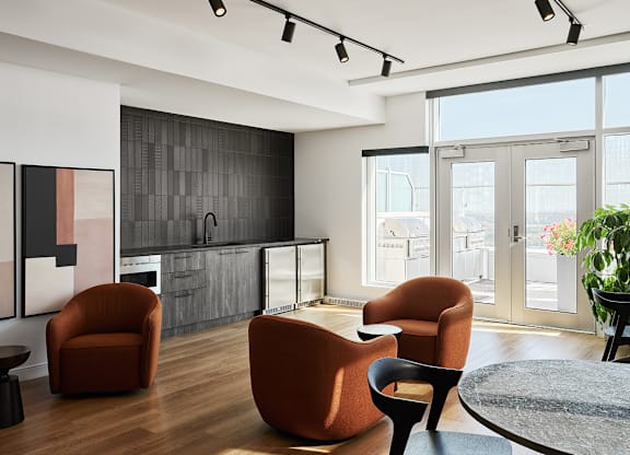 A modern living room with a black tiled wall and a glass door leading to a balcony.