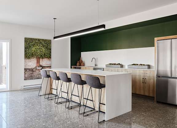 A modern kitchen with a bar area and stools at Champlain Village Urbain Apartments , Gatineau, Quebec