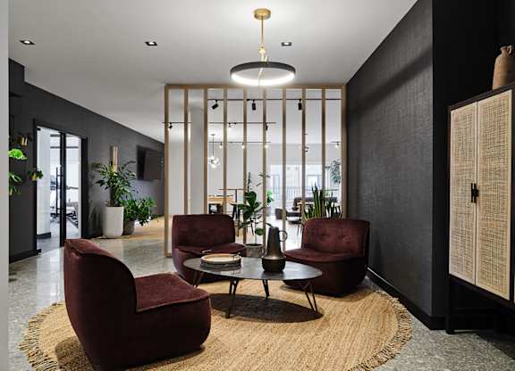 A modern living room with a large rug and a round table with four chairs at Champlain Village Urbain Apartments , Gatineau