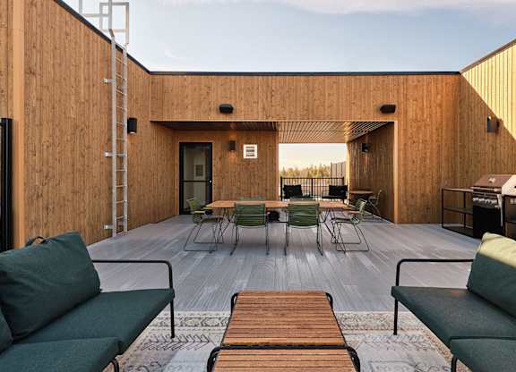 A wooden deck with a table and chairs is surrounded by a wooden wall at Champlain Village Urbain Apartments , Gatineau, QC