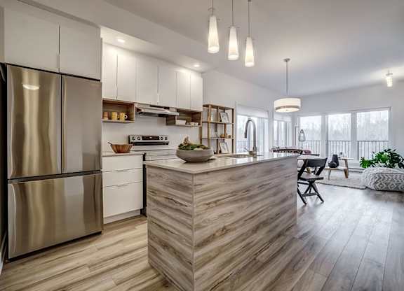 A modern kitchen with a wooden island and stainless steel appliances at Champlain Village Urbain Apartments , Gatineau, QC, J9H 0K9