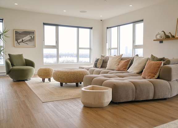 A living room with a large couch, a green chair, and a rug. at Château golf, Quebec