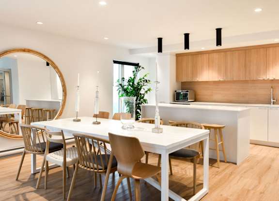 A modern dining room with a white table and chairs. at Château golf, Gatineau
