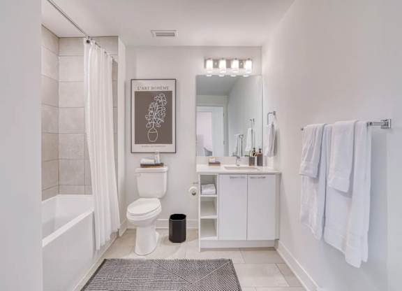 A bathroom with a toilet, sink, and a picture of an earl. at Château golf, Gatineau