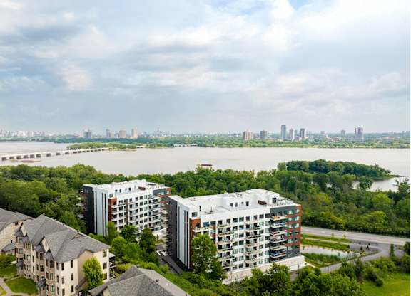 A river flows through a city with apartment buildings on both sides. at Château golf, Gatineau, QC J9H 0M9