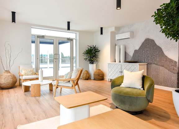 A living room with a green chair and a white couch. at Château golf, Gatineau, QC J9H 0M9