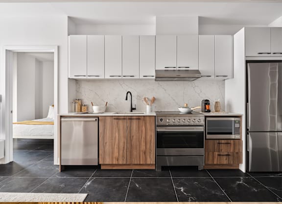 A modern kitchen with stainless steel appliances and wooden cabinets. at Le ColumbiaApartments , Gatineau, QC, J8Y 0A8