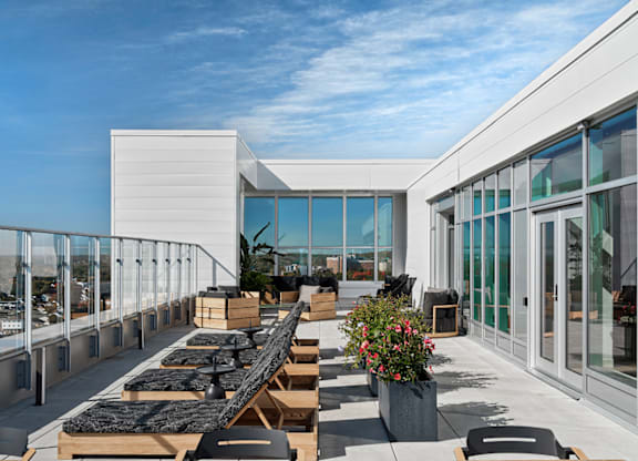 A modern outdoor dining area with wooden tables and chairs. at Le ColumbiaApartments , Gatineau, QC, J8Y 0A8