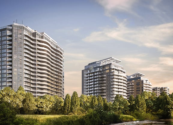 A modern building complex with a river in the foreground at Petries Landing I Apartments , Ottawa, K4A 1K4